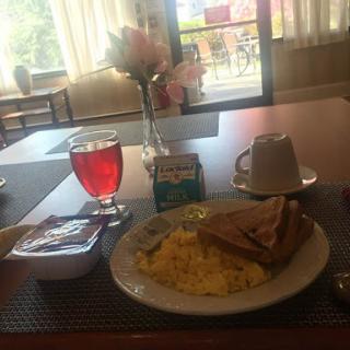 A delicious breakfast spread featuring scrambled eggs, toast, and a refreshing drink.