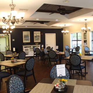 A well-decorated dining area with tables, chairs, and chandeliers.