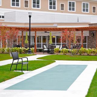 A modern building with a landscaped garden and seating area.