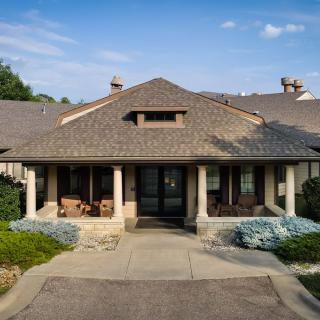 A suburban house with a welcoming porch and landscaped front yard.