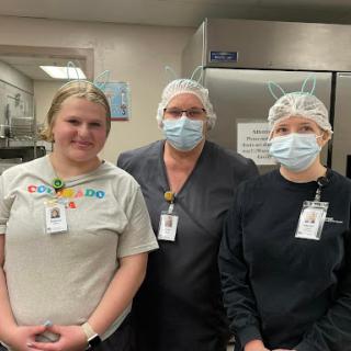 Healthcare workers in a kitchen setting, showcasing their commitment to safety and teamwork.