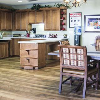 A cozy kitchen and dining area featuring wooden cabinets, a hardwood floor, and a dining table with chairs.