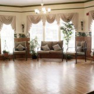 A spacious living area with elegant decor, featuring large windows, soft curtains, and comfortable seating.