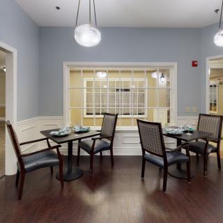 A modern dining area with neatly arranged tables and chairs, featuring stylish lighting.