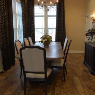 A well-appointed dining room with a wooden table, cushioned chairs, and a stylish chandelier.
