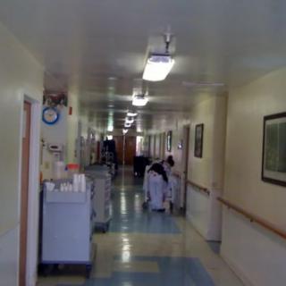 A hospital corridor with medical staff and equipment.