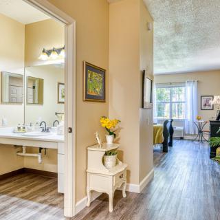 A cozy interior showcasing a bathroom and living room with soft lighting and elegant decor.