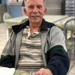 An older gentleman enjoying a moment at a restaurant.