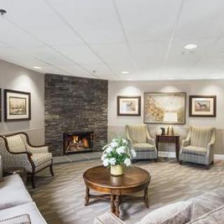A cozy living room with a fireplace, elegant seating, and modern decor.