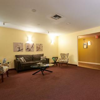 A comfortable lobby area with seating, artwork, and warm lighting.