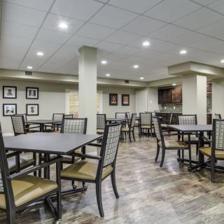 A modern dining area with neatly arranged tables and chairs under bright lighting.
