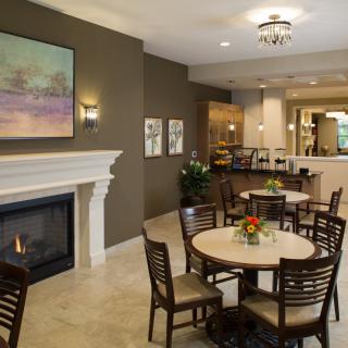 Cozy and elegant dining area with a fireplace, decorated with flowers and artwork.
