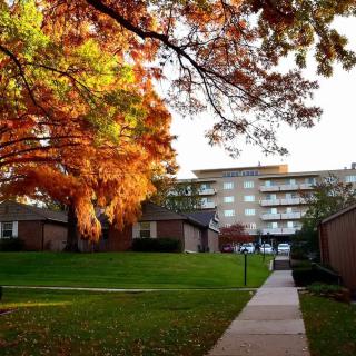 A scenic view of a residential building surrounded by vibrant autumn foliage.