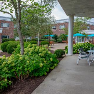 A serene outdoor space featuring a well-maintained garden and seating area, perfect for relaxation.