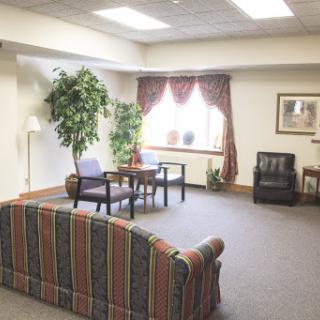 A cozy and inviting living room space featuring comfortable seating and greenery.