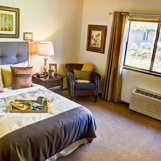 A cozy and well-decorated bedroom with a comfortable bed, stylish furniture, and ample natural light.