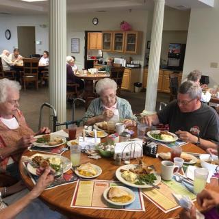 A group of elderly people enjoying a meal together in a community setting.