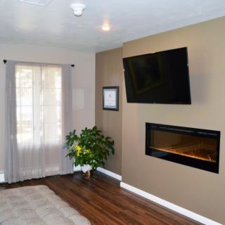 A cozy living room with a mounted television and modern fireplace.