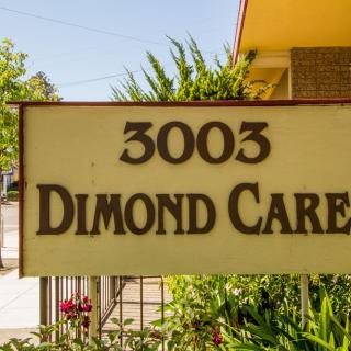 A sign displaying the address '3003 Dimond Care' in front of a building with surrounding greenery.