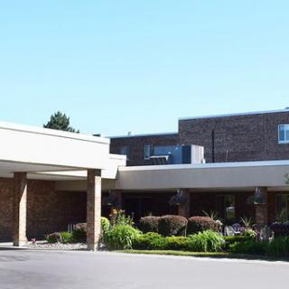 A hospital building with an entrance and landscaped surroundings.