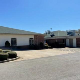 A view of a building with a parking lot under a clear blue sky.