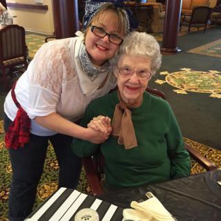 Two women smiling and posing together indoors.