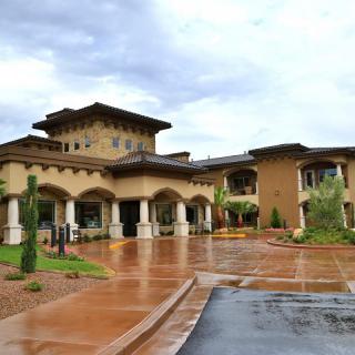 A luxurious resort building with a grand entrance and a cloudy sky backdrop.
