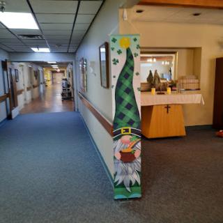 A festive decoration featuring a green Christmas tree and a snowman in a hallway.