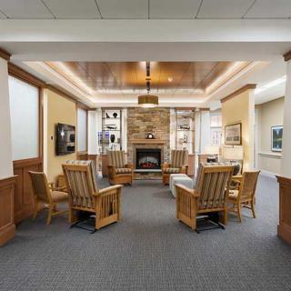 A cozy lobby area featuring comfortable wooden furniture and a fireplace.