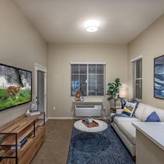 A cozy and modern living room with a comfortable sofa, wall-mounted TV, and stylish decor.
