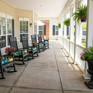A cozy porch with rocking chairs and potted plants.