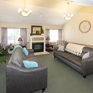 A cozy living room with two sofas, a fireplace, and elegant lighting fixtures.