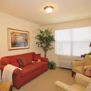 Cozy living room with a red sofa and beige armchairs.