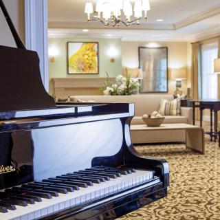 A luxurious living room featuring a grand piano and elegant decor.