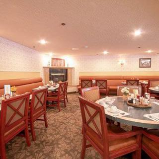 An empty restaurant dining area with neatly arranged tables and chairs.