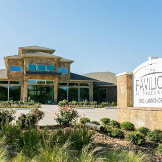 Entrance of The Pavilion at Creekwood with landscaped surroundings.