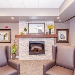 A cozy living room with a modern fireplace and comfortable armchairs.