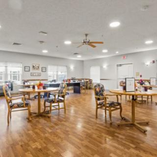 Spacious dining room with wooden floors and arranged tables.