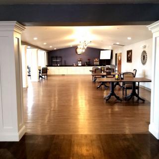 An elegant dining hall with wooden floors and a chandelier.