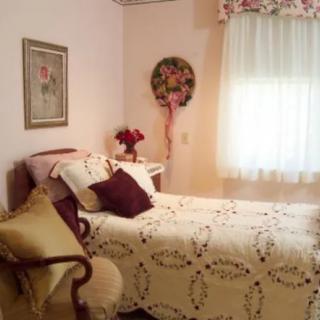 A cozy vintage-style bedroom with a neatly made bed and decorative accents.