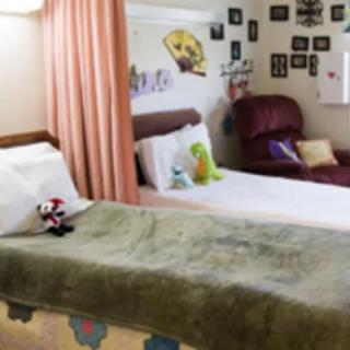 A cozy bedroom with a comfortable bed, pillows, and colorful decor.