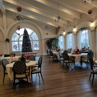A festive dining area adorned with Christmas decorations and a large tree.