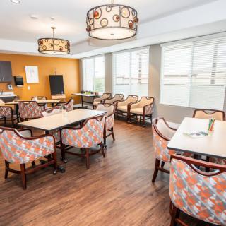 A modern dining area with patterned chairs and large windows.