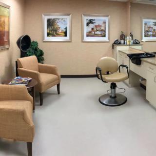 A well-appointed hair salon with comfortable seating and art-adorned walls.