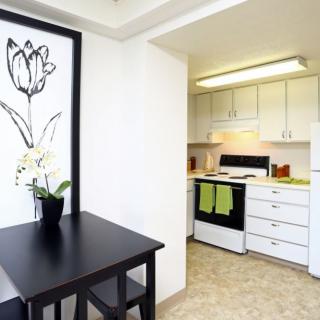 A modern kitchen and dining area with white cabinets and minimalistic decor.