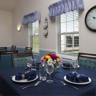 A beautifully set dining table with blue accents, featuring fresh flowers and an inviting atmosphere.