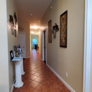 A well-lit hallway with decorative artwork and tiled flooring.