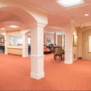 A spacious lobby area with columns and carpet flooring.