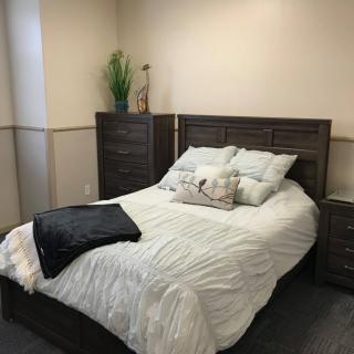 A cozy bedroom with a neatly made bed and wooden furniture.
