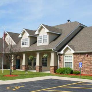 A suburban residential building with a well-maintained lawn and driveway.